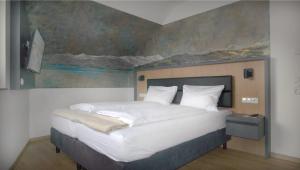 a bedroom with a large bed with a painting on the wall at DaSalvatore in Wasserburg am Bodensee