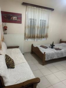 a bedroom with two beds and a window at Gellis Village house Meteora in Kalabaka