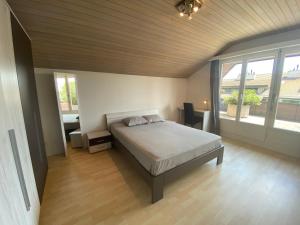 um quarto com uma cama e uma grande janela em LakeVIEW Penthouse in the heart of Switzerland em Sempach