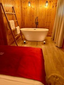 La salle de bains est pourvue d'une baignoire et d'un mur en bois. dans l'établissement Flumen Park, à Tirana