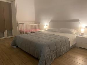 a bedroom with a bed and two lamps and a crib at Residenza Mazzini in Avezzano