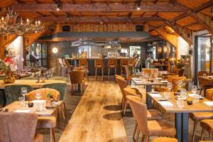 a restaurant with wooden floors and tables and chairs at Chalet vakantiepark Beekbergen in Beekbergen
