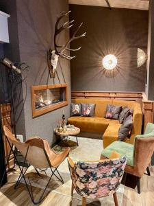 a living room with a couch and some chairs at Chalet vakantiepark Beekbergen in Beekbergen