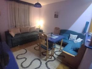 a living room with a blue table and a couch at Apartman MAJA in Zlatibor