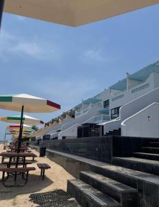 ein Gebäude mit Treppen und Sonnenschirmen am Strand in der Unterkunft غرفة صالة بلكونة على الشاطئ - عوائل in Durrat Al-Arus