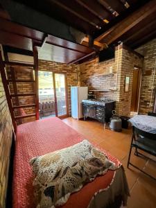 a bedroom with a bed and a stove at Moradas Girassol in Guarda do Embaú