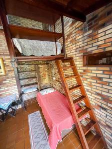 a room with two bunk beds in a brick wall at Moradas Girassol in Guarda do Embaú