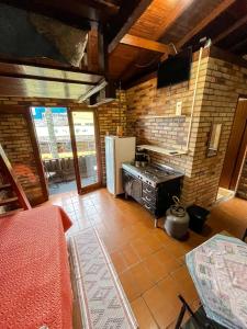 a kitchen with a stove and a refrigerator at Moradas Girassol in Guarda do Embaú