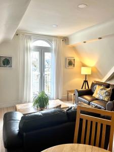 a living room with a black leather couch and a table at Holland House in New Brighton