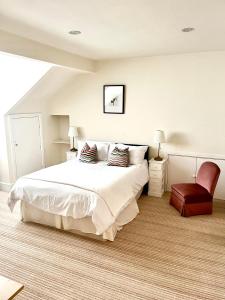 a bedroom with a large white bed and a chair at Holland House in New Brighton