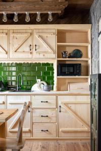 a kitchen with wooden cabinets and a microwave at Leśna Chatka in Dzianisz