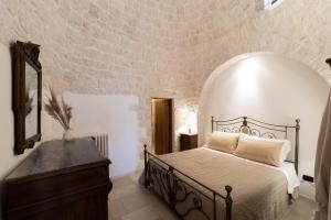 a bedroom with a bed and a mirror and a dresser at Trulli Angela in Locorotondo