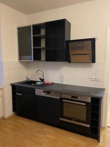 a kitchen with a black counter top and a sink at Komfortable Wohnung in Magdeburg +3 photos