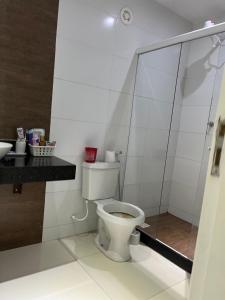 uma casa de banho com um WC e uma cabina de duche em vidro. em Quarto luxo barra da Tijuca no Rio de Janeiro