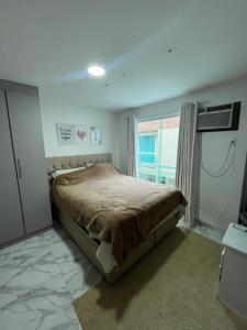 1 dormitorio con cama y ventana en Quarto luxo barra da Tijuca, en Río de Janeiro