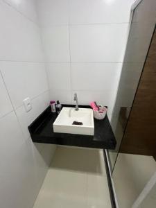 a bathroom with a sink and a black counter at Quarto luxo barra da Tijuca in Rio de Janeiro
