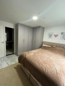 1 dormitorio con 1 cama grande y armarios blancos en Quarto luxo barra da Tijuca, en Río de Janeiro
