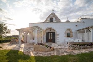 ein weißes Haus mit Pergola und Terrasse in der Unterkunft Trulli Angela in Locorotondo