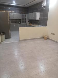 uma grande cozinha com uma parede branca e um piso de azulejo em هلتون بلو em Meca