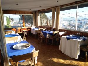 a restaurant with tables and chairs with blue tablecloths at Hotel Puerto Mayor in San Antonio