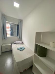 a small room with a bed and a shelf at Casa de Mainha - Vila Mariana - unidade 1 in Sao Paulo