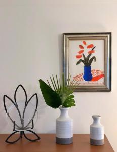 three vases sitting on a table with a painting at Central London Apartment - Yvonné in London