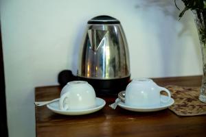 - Hervidor de té y 2 tazas en una mesa en Jasmine Cabanas en Unawatuna