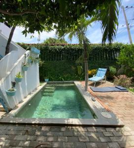 uma pequena piscina com uma cadeira num quintal em Casa San Sebastian em Santa Marta