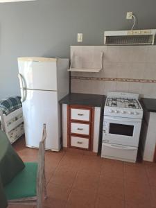 a kitchen with a white refrigerator and a stove at Departamento en Balcarce in Balcarce