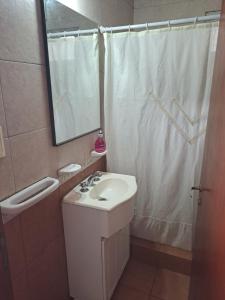 a bathroom with a sink and a mirror and a shower at Departamento en Balcarce in Balcarce