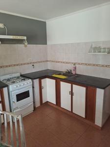 a small kitchen with a stove and a sink at Departamento en Balcarce in Balcarce