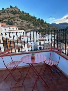 d'une table et de deux chaises sur un balcon. dans l'établissement Casa Nieves -La buardilla del cielo, à Villahermosa del Río