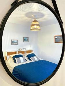a bedroom with a blue bed with a mirror at Appartement T2 rénové proche plage Vieille Chapelle Marseille in Marseille
