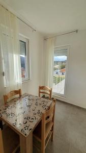 a dining room with a table and chairs and a window at Deutsche Willa in Sutomore +25 photos