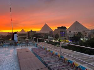 a woman standing on a balcony looking at the pyramids at Matto Pyramids Inn in Cairo