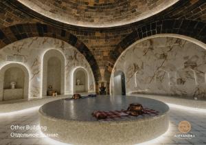 a large room with a stone wall and a circular table at Shiraz Plaza Hotel & Spa in Gyumri