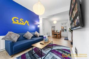 a living room with a blue couch and a table at Stylist and Cosy 3 Bed House Sleeps 7 Free Parking in London