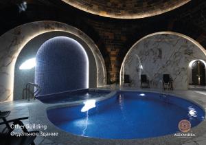 a large swimming pool in a building with an archway at Shiraz Plaza Hotel & Spa in Gyumri