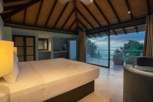 a bedroom with a bed and a view of the ocean at Ravana Garden in Ambalantota