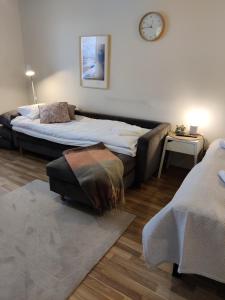 um quarto com duas camas e um relógio na parede em Hilla Apartments em Rovaniemi