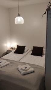 two beds in a white room with towels on them at Hilla Apartments in Rovaniemi