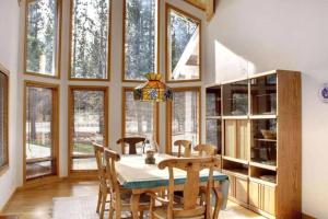 a dining room with a table and some windows at Lakefront Estate W/Stunning Views in Big Bear Lake in Big Bear Lake
