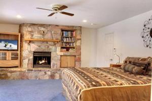 1 dormitorio con chimenea de piedra y 1 cama en Lakefront Estate W/Stunning Views in Big Bear Lake en Big Bear Lake