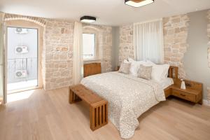 a bedroom with a bed and a stone wall at Villa Basca in Baška Voda