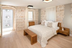 een slaapkamer met een bed en een stenen muur bij Villa Basca in Baška Voda