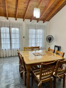 Un comedor con una gran mesa y sillas de madera. en Casa con pileta cerca del Parque, en Godoy Cruz