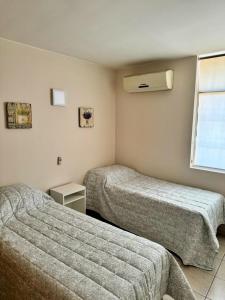 a hotel room with two beds and a window at Casa con pileta cerca del Parque in Godoy Cruz