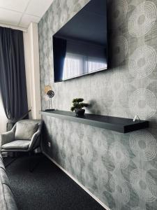 een woonkamer met een spiegel en een stoel bij Firstclass Event & Hotel in Fürth