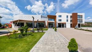 a large white building with a lawn in front of it at Hotel Dijana in Pirot