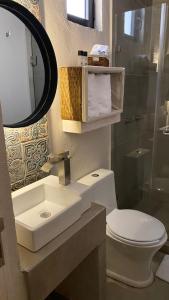 uma casa de banho com um lavatório, um WC e um espelho. em Altamonte Hotel Boutique em Bernal